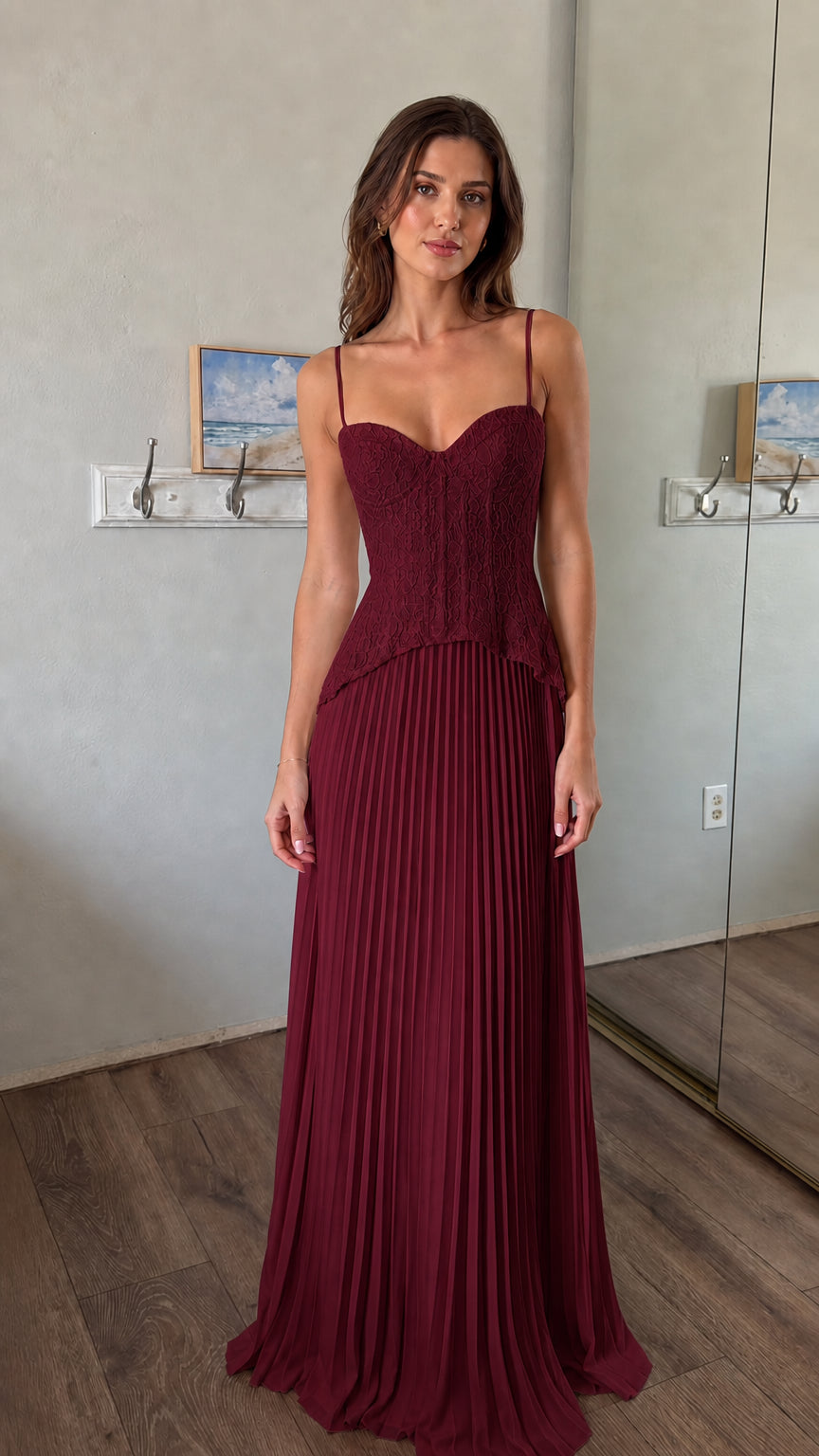 Front view of woman wearing burgundy lace corset bodice pleated maxi dress