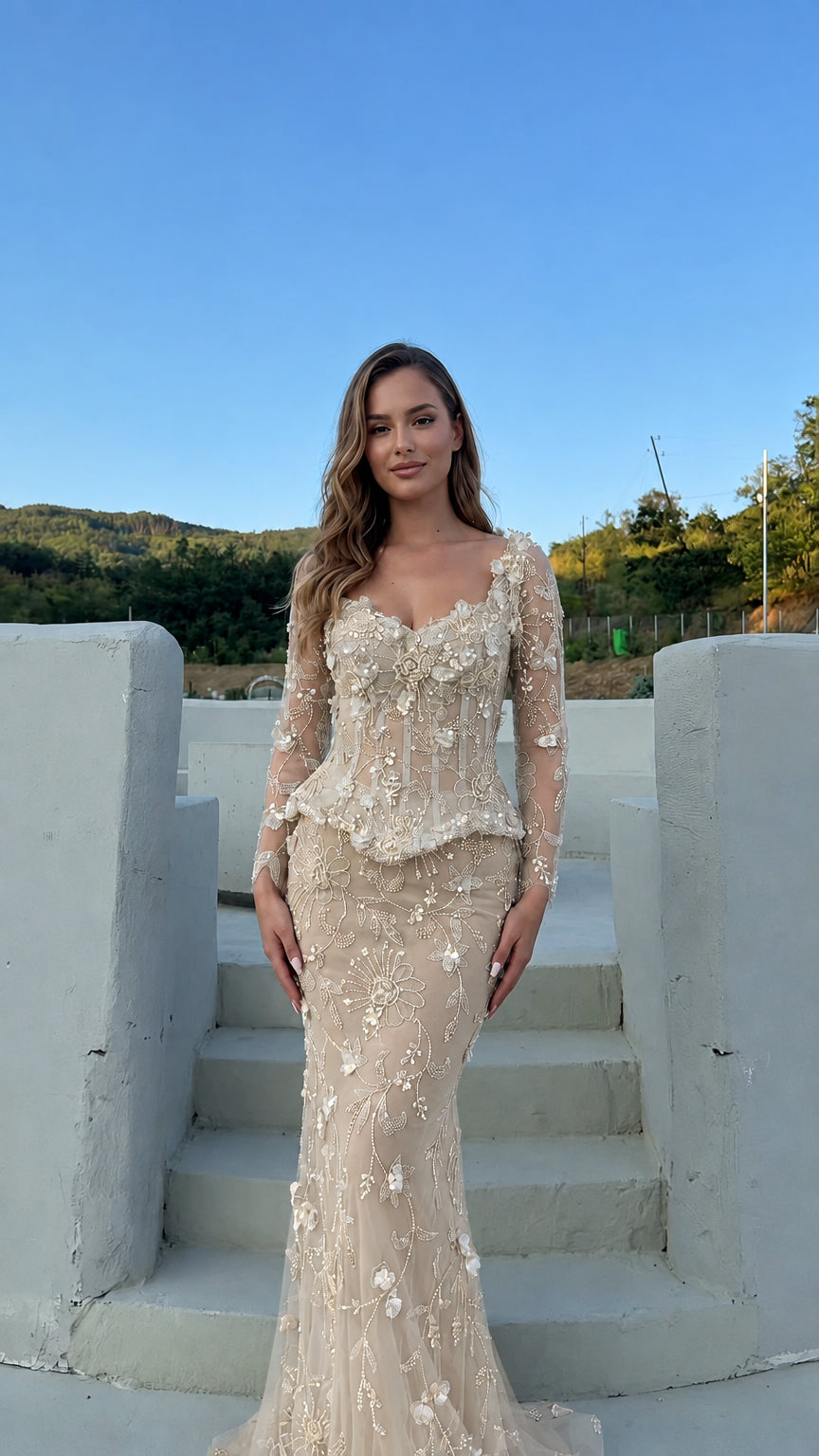 Model wearing the floral appliqué corset peplum evening gown in champagne