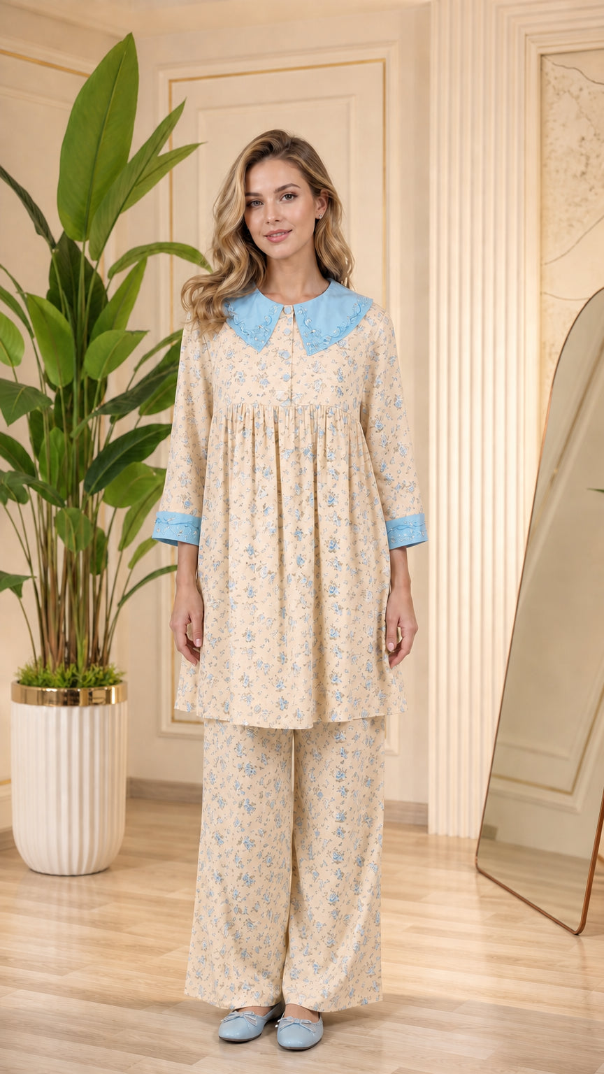 Model wearing beige floral pajama set with light blue contrast collar and cuffs