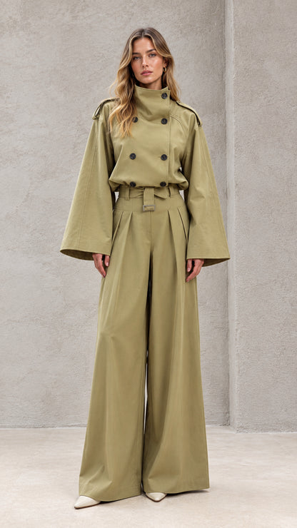 Front full-length view of model wearing sage green double-breasted wide-leg trench jumpsuit