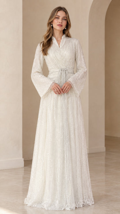 Front view of model wearing white sequined long sleeve maxi evening dress with belted waist