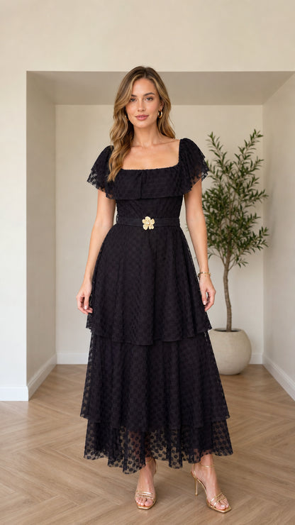 Front view of black tiered square neck maxi dress with floral buckle belt