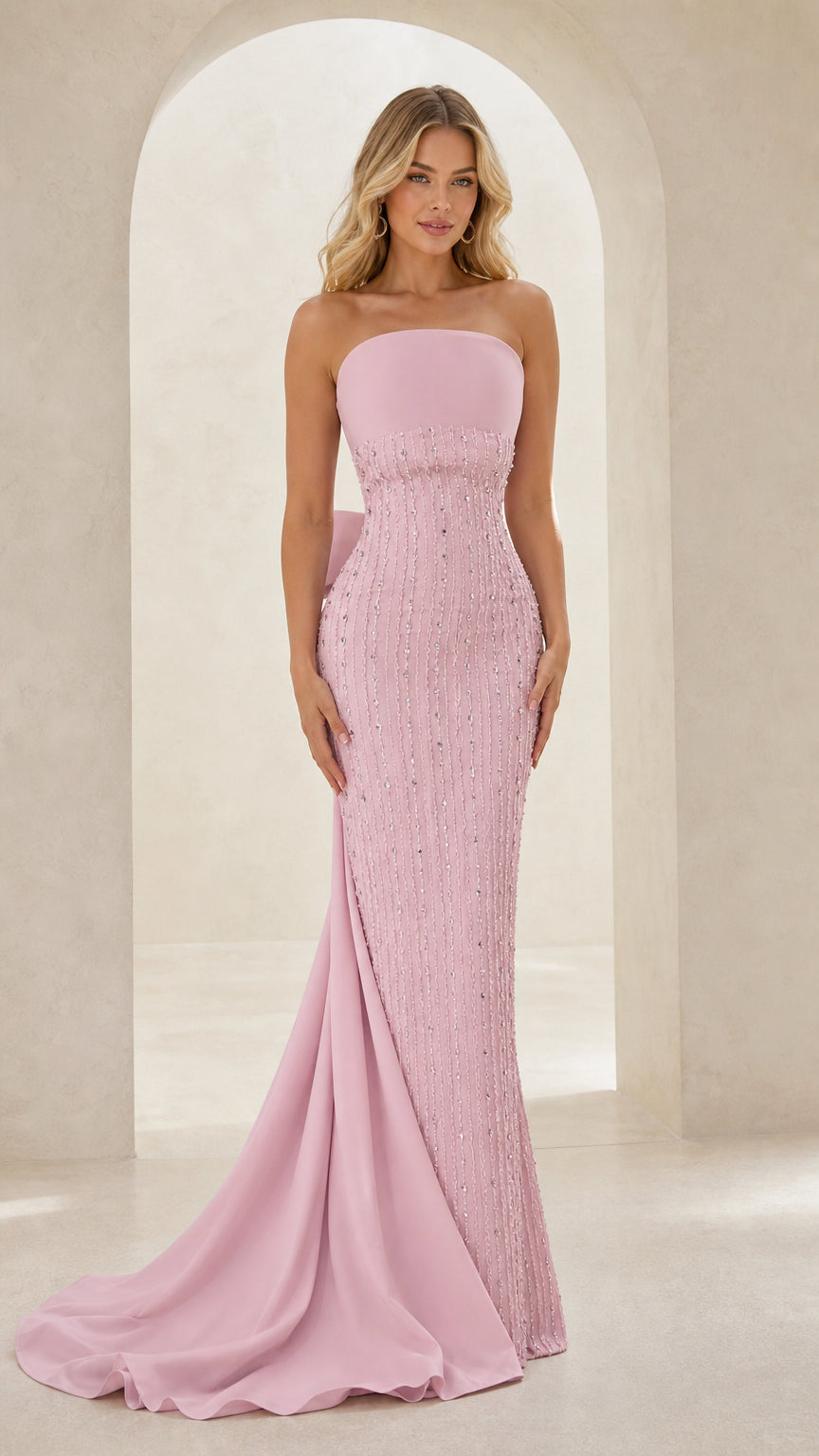 Front view of model wearing strapless beaded blush pink evening gown with train