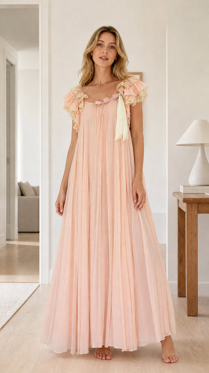 Full front view of model wearing a flowing blush pink pleated maxi nightgown with lace flutter sleeves