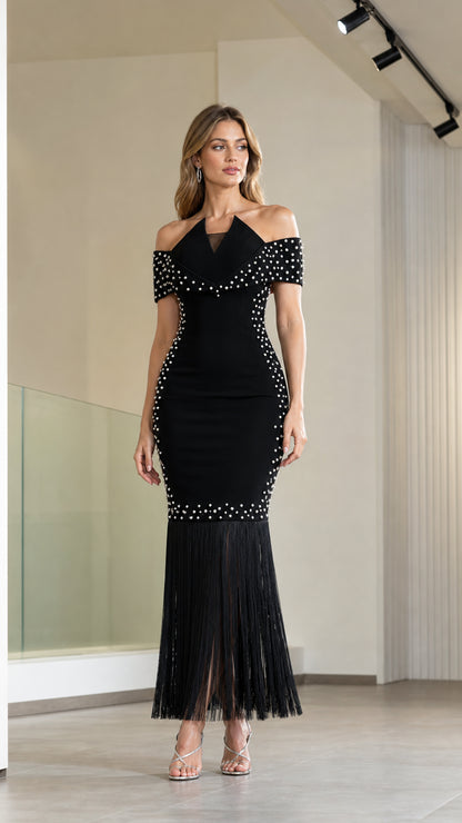 Front view of model wearing black off-the-shoulder pearl embellished fringe maxi evening dress