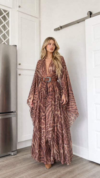 Front full-length view of woman wearing brown abstract animal print kimono maxi dress with western belt