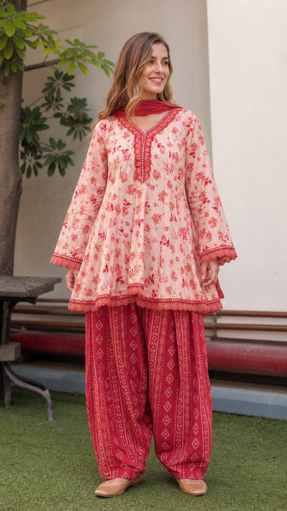Front view of model wearing peach floral peplum tunic and red dhoti pants