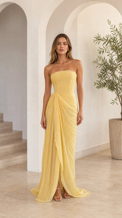 Front full-length view of model wearing yellow strapless ruched draped maxi gown
