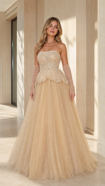 Front view of model wearing strapless champagne beaded peplum tulle ballgown