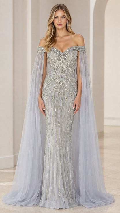 Front view of model wearing a slate blue beaded off-the-shoulder mermaid gown with sheer cape sleeves