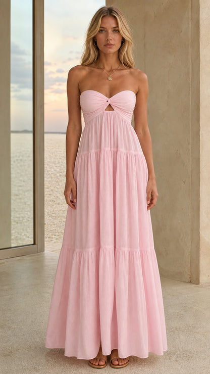 Front view of a pink strapless twist-front tiered maxi dress