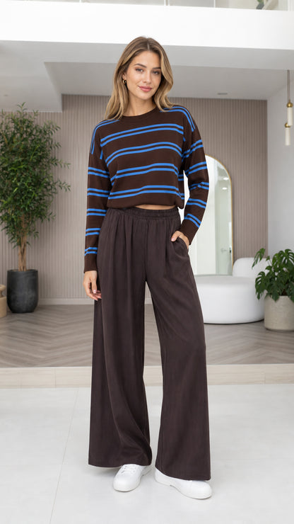 Front view of model wearing brown and blue striped cropped sweater with dark brown wide-leg pants