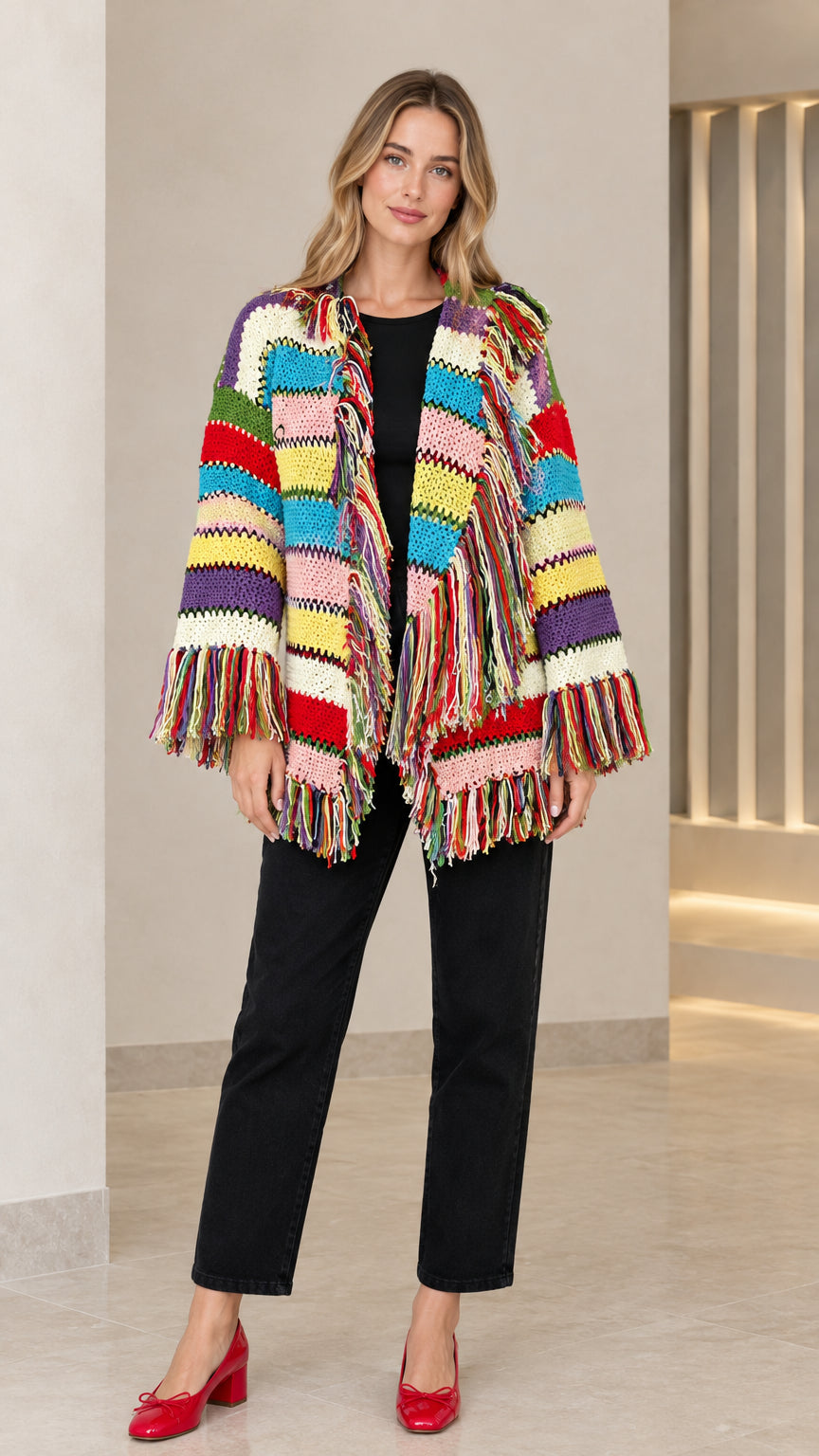 Front view of model wearing white multicolor striped fringe knit cardigan with black top and pants