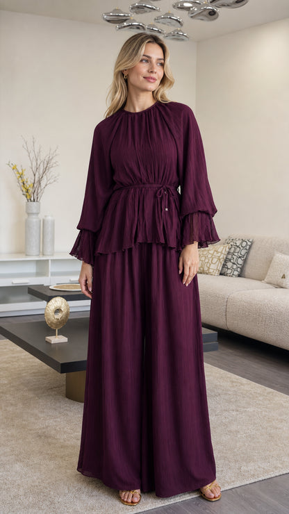 Front full view of woman wearing Plum pleated peplum top and wide leg pants set