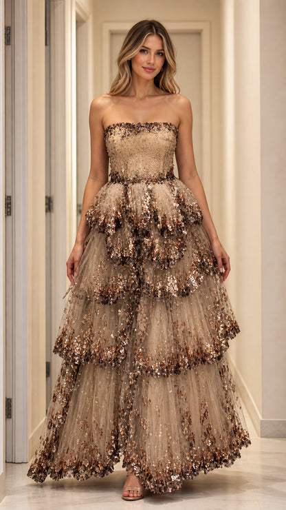 Front view of model wearing champagne strapless tiered sequin evening gown