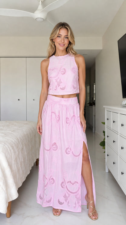Front view of model wearing pink two-piece crop top and maxi skirt set
