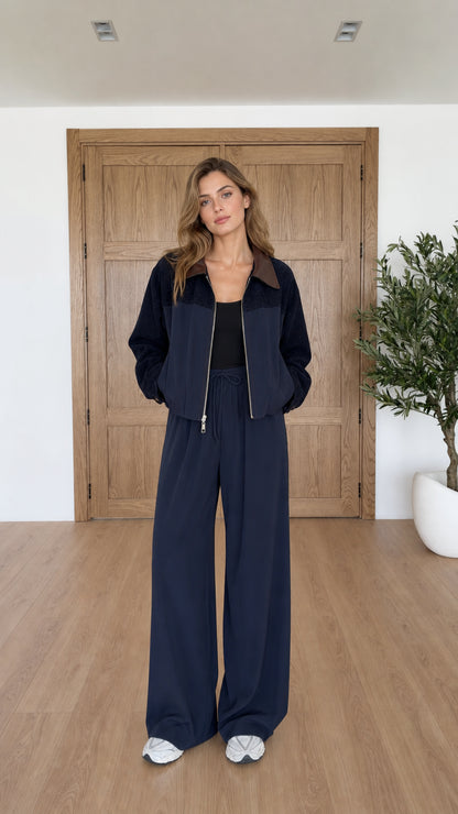 Front view of model wearing navy blue contrast collar zip jacket and wide leg pants set