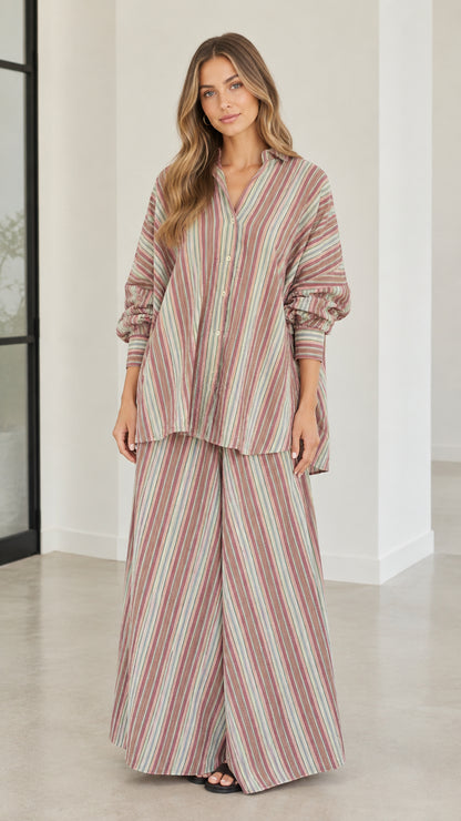 Full front view of model wearing rust multi-color striped oversized shirt and wide-leg pants set