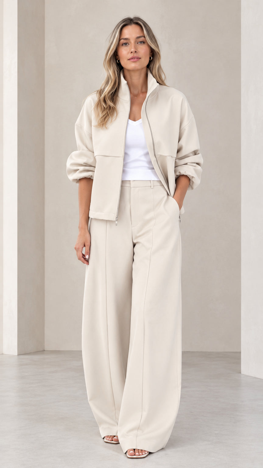 Full front view of women's beige zip-up jacket and wide-leg trousers two-piece set