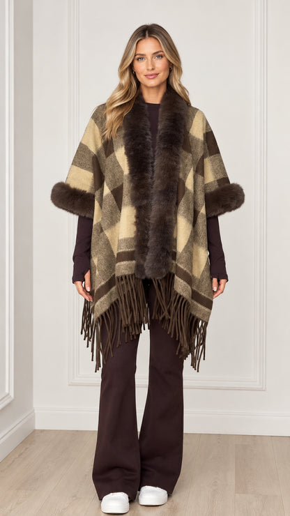 Woman wearing olive khaki plaid poncho with faux fur collar and fringe hem - front view