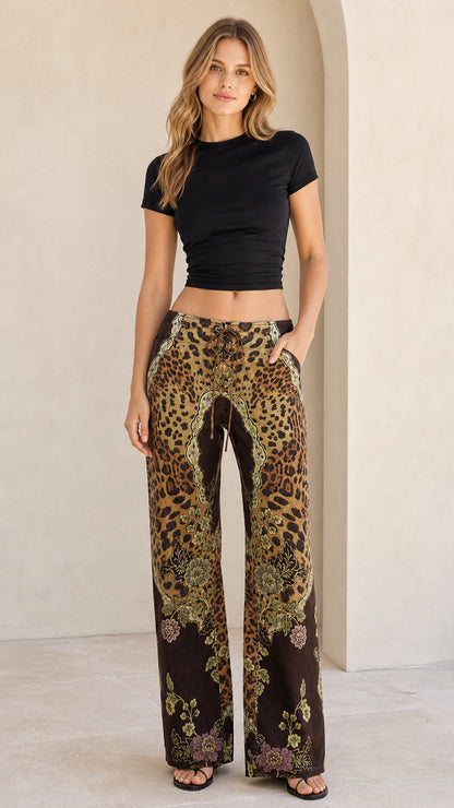 Full front view of model wearing brown leopard and baroque print lace-up wide leg pants