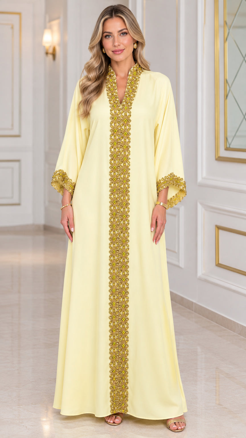 Front view of woman wearing pale yellow kaftan maxi dress with gold embroidered trim