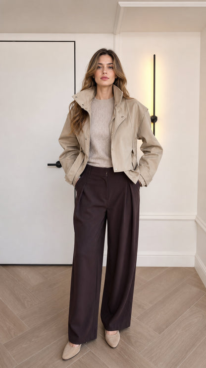 Front full-body view of model wearing beige cropped faux leather jacket and wide-leg trousers