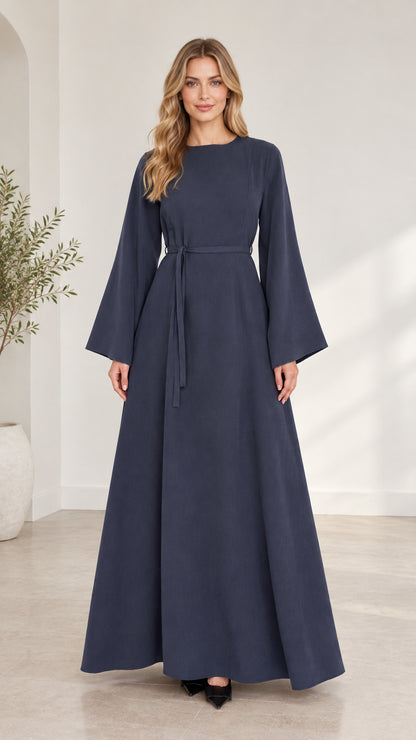 Full front view of woman wearing navy blue long bell sleeve modest maxi dress with waist tie
