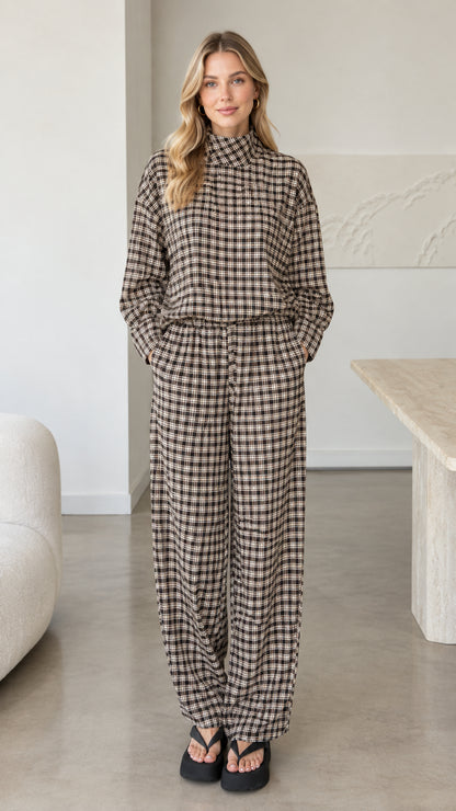 Front view of woman wearing brown plaid mock neck top and wide leg pants set