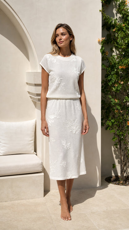Front view of woman wearing white floral embroidered knit midi dress