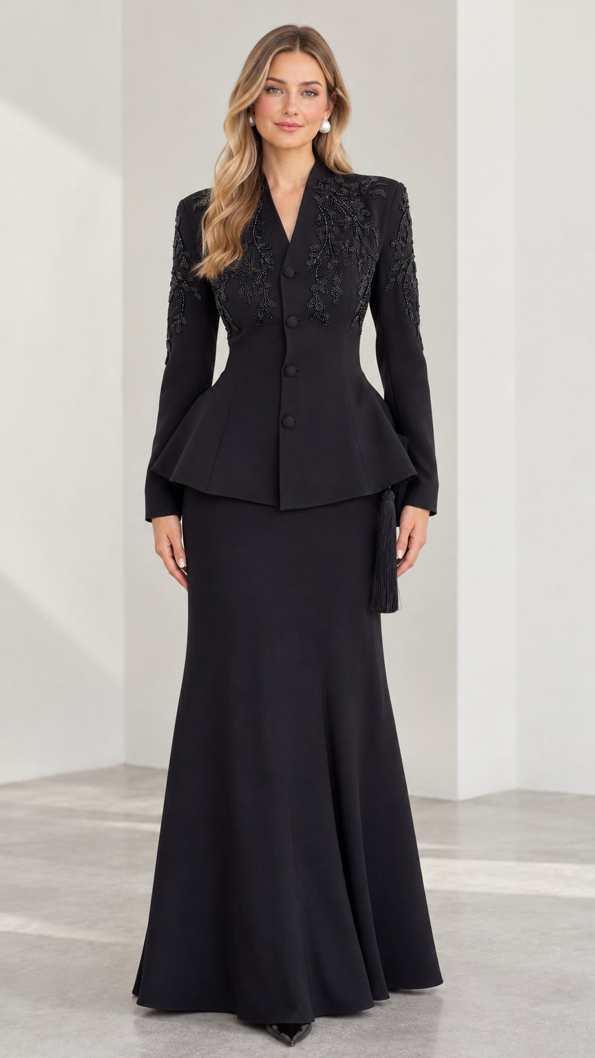 Front view of black embroidered peplum jacket and maxi skirt evening suit