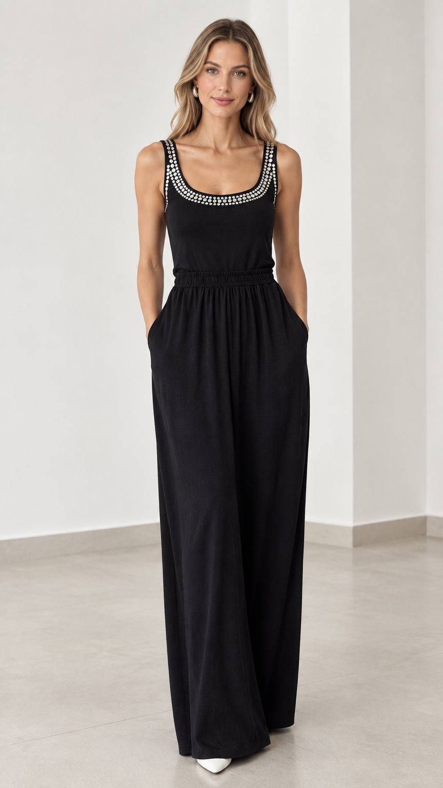Front view of model wearing black rhinestone scoop neck wide leg jumpsuit with pockets
