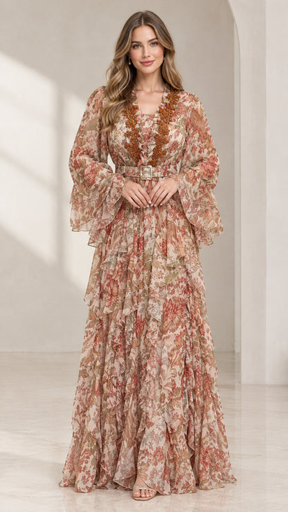 Front view of woman wearing blush floral print tiered maxi dress with matching belt