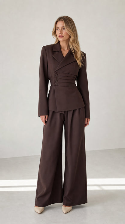 Front view of woman wearing chocolate brown cinched waist blazer and wide leg trousers set