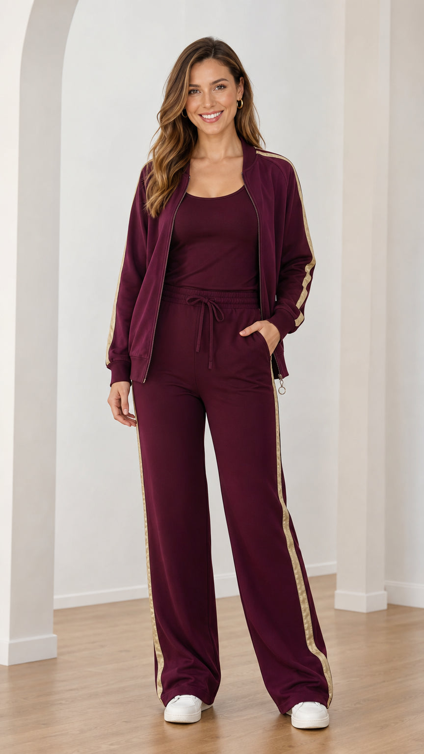 Front view of woman wearing burgundy 3-piece tracksuit set with metallic side stripes