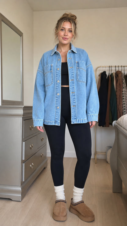 Front view of model wearing light blue oversized denim shacket with black leggings
