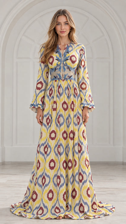 Front view of woman wearing yellow ikat print pleated maxi dress with embroidered bodice