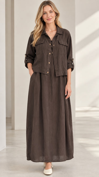 Front view of model wearing dark brown collared shirt jacket and matching pleated maxi skirt set