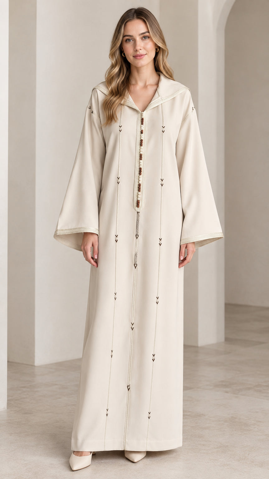 Front full view of woman wearing cream hooded Moroccan djellaba maxi dress with braided trim