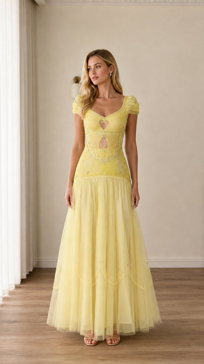 Front full-length view of woman in pastel yellow beaded cutout tulle evening gown