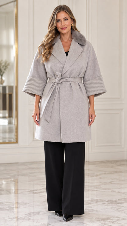 Front view of model wearing light grey belted wrap coat with faux fur collar and wide-leg trousers