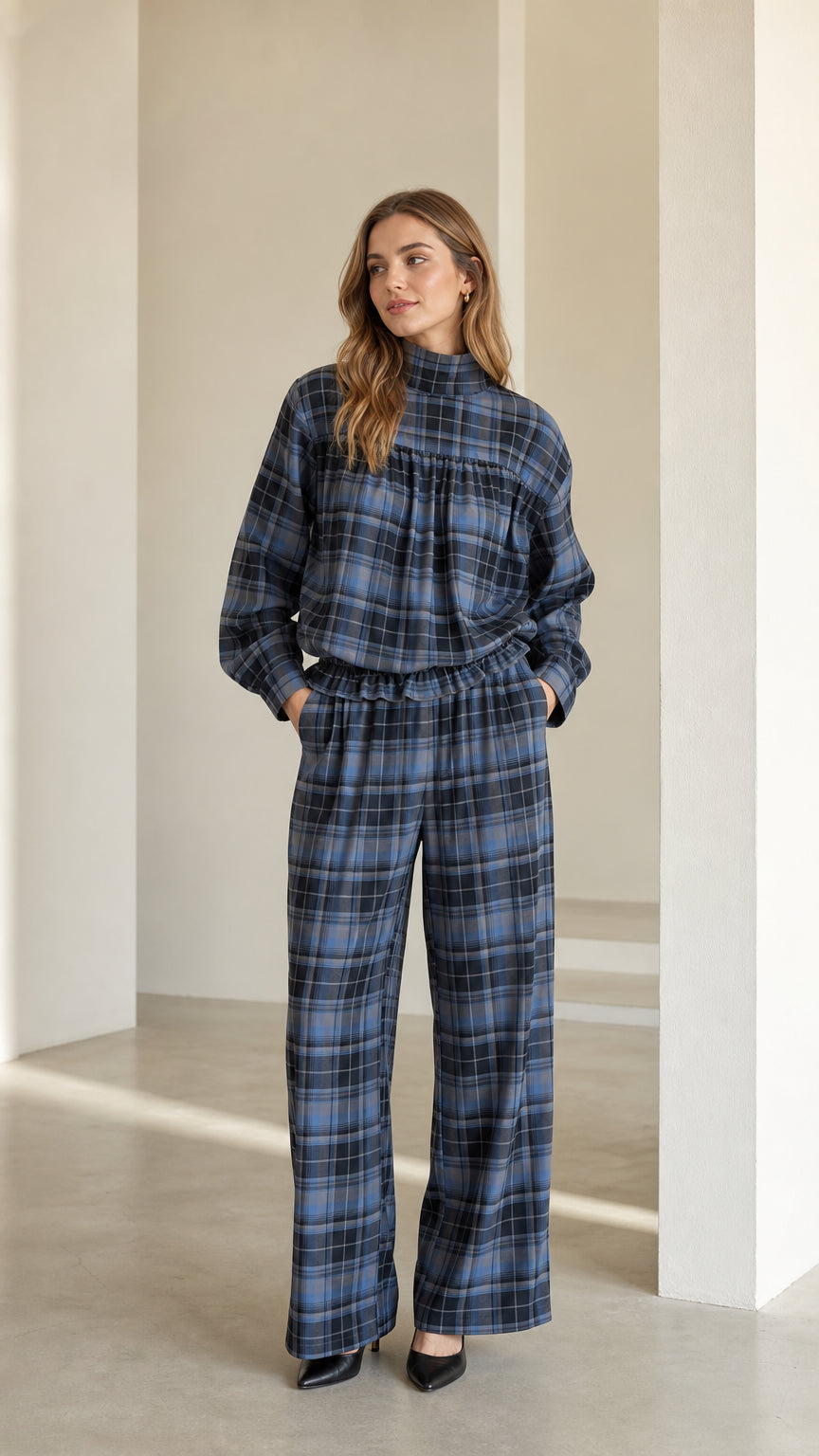 Front full-length view of model wearing blue plaid mock neck top and wide leg pants set