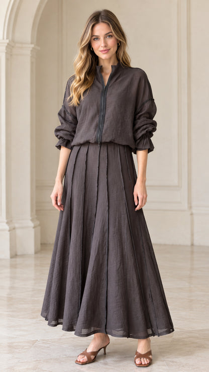Front view of woman wearing charcoal grey textured zip-front top and pleated maxi skirt set