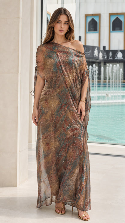 Front view of woman wearing Bronze Multi asymmetrical kaftan maxi dress with ruched shoulder