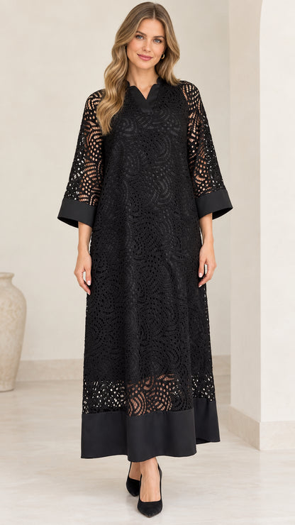 Front view of model wearing black lace overlay maxi dress with solid trim