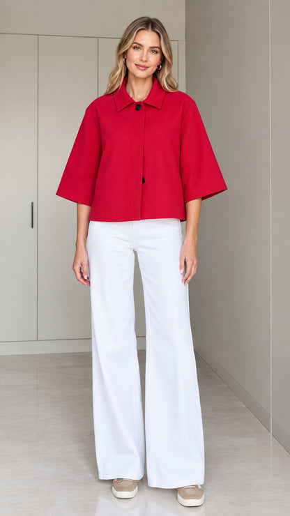 Front full-length view of a woman wearing a red cropped half-sleeve swing jacket with white wide-leg trousers