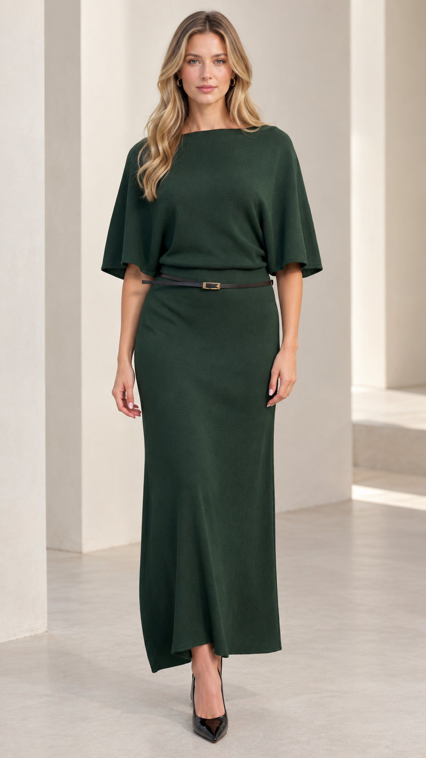 Front view of woman wearing elegant dark green knit maxi dress with flutter sleeves and belt