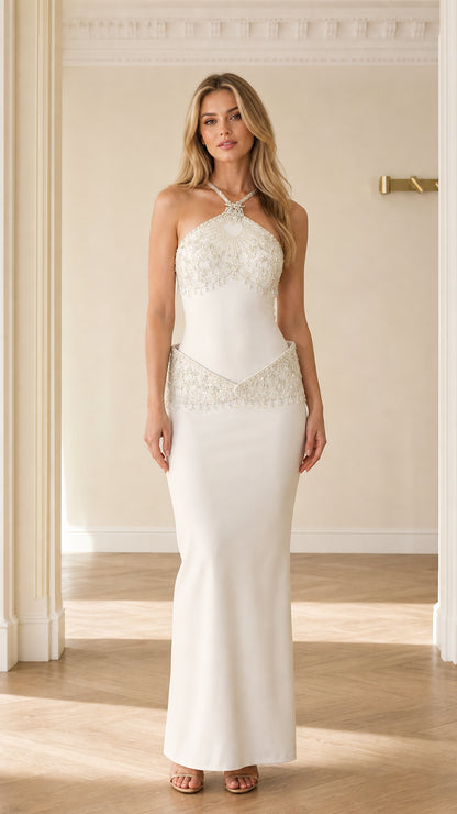 Front full-length view of white beaded halter neck drop waist maxi evening gown