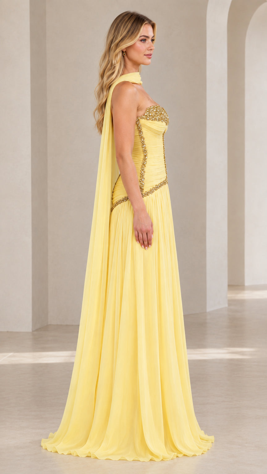 Side profile view of model wearing pastel yellow formal chiffon gown with draped neck scarf