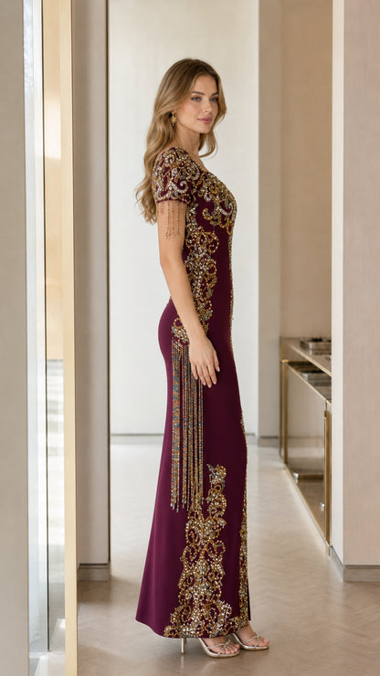 Side profile view of burgundy beaded maxi dress showcasing fitted silhouette and sleeve fringe